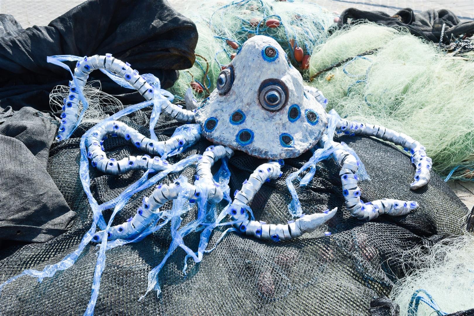 תמנון הטבעות הכחולות נלכד ברשת הדייגים ונאבק בשקיות הניילון החונקות את גופו