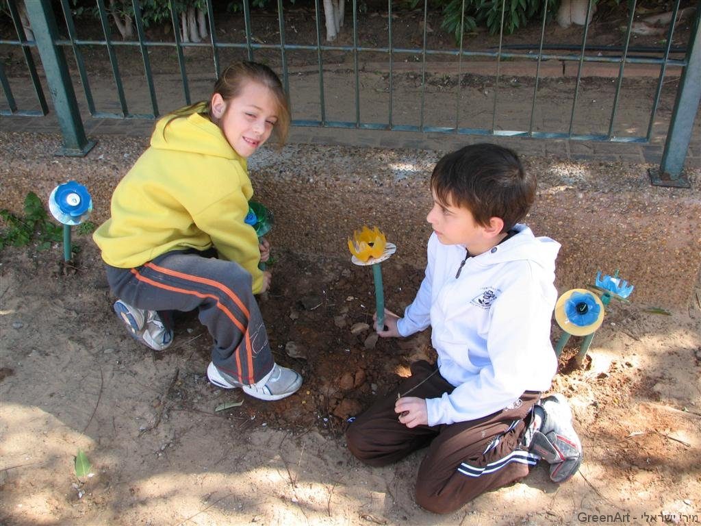 התלמידים נהנים לשתול את הפרחים שיצרו מבקבוקי פלסטיק התלמידים נהנים לשתול את הפרחים שיצרו מבקבוקי פלסטיק