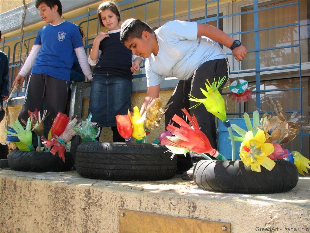 פרחים מעוצבים בתוך אדניות מצמיגים ישנים