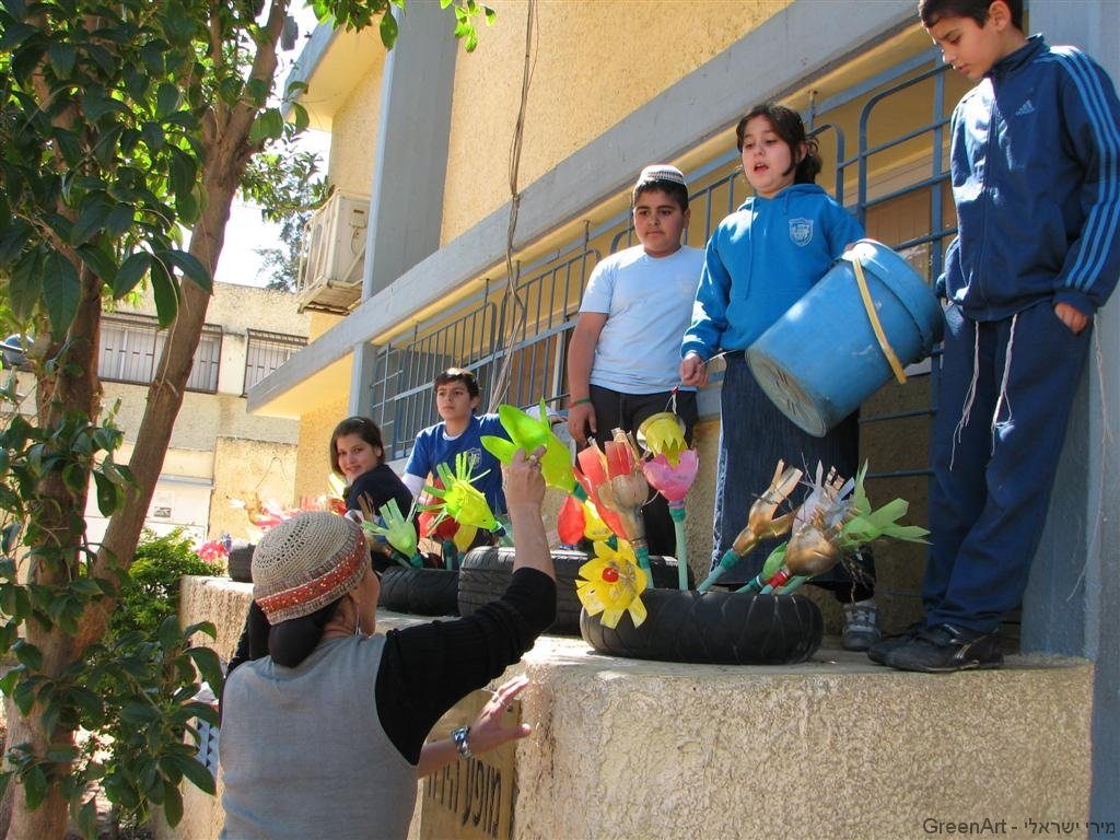 תלמידי בית ספר סיני מעצבים את הפרחים בתוך הצמיגים