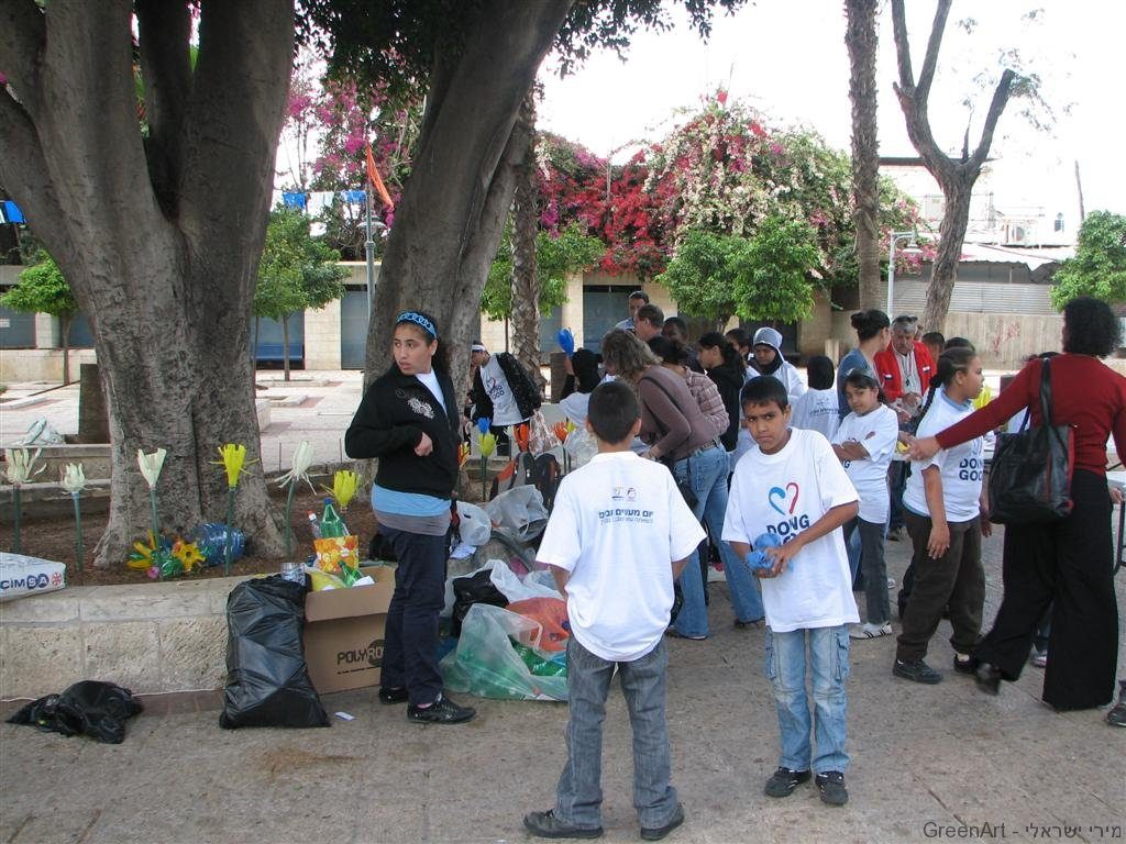 התלמידים נוטעים את פרחי הפלסטיק בגינות במרחב העירוני