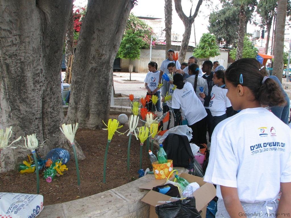 התלמידים נוטעים את פרחי הפלסטיק בגינות במרחב העירוני