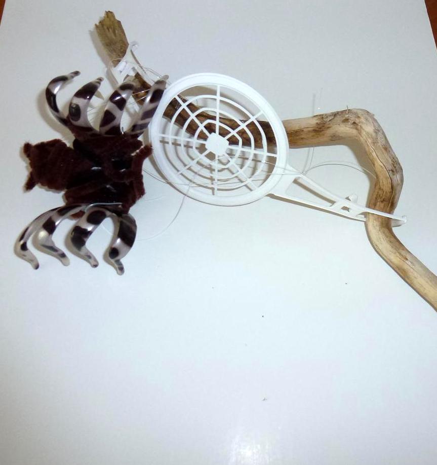 עכביש טווה חוטים ממוצרי פלסטיק- אומנות אקולוגית