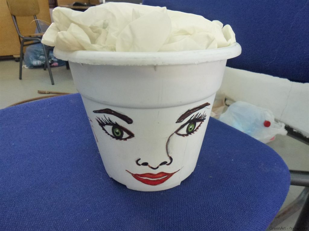 פנים מצוירות על עציץ פלסטיק בשימוש חוזר