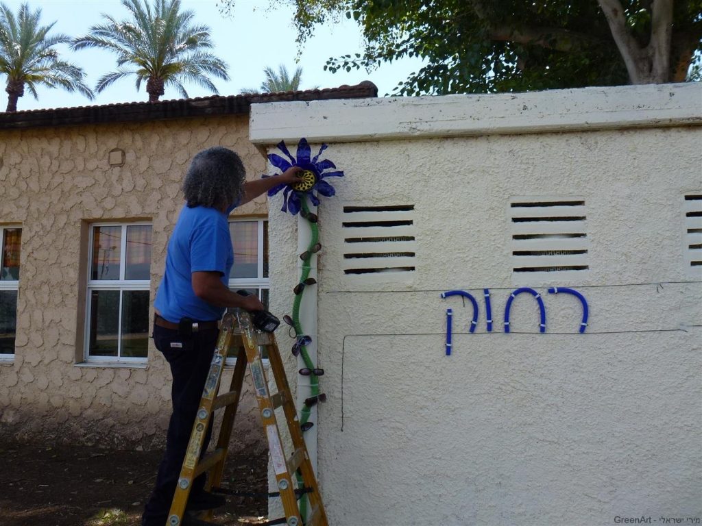 יורם מרכיב ובודק את חוזק הפרח לצינור