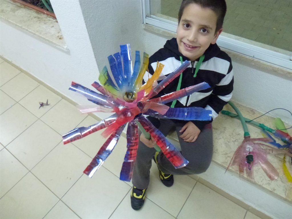 ילד יצירתי מציג בגאווה את הפרחים הצבעוניים שעיצב עם אביו 