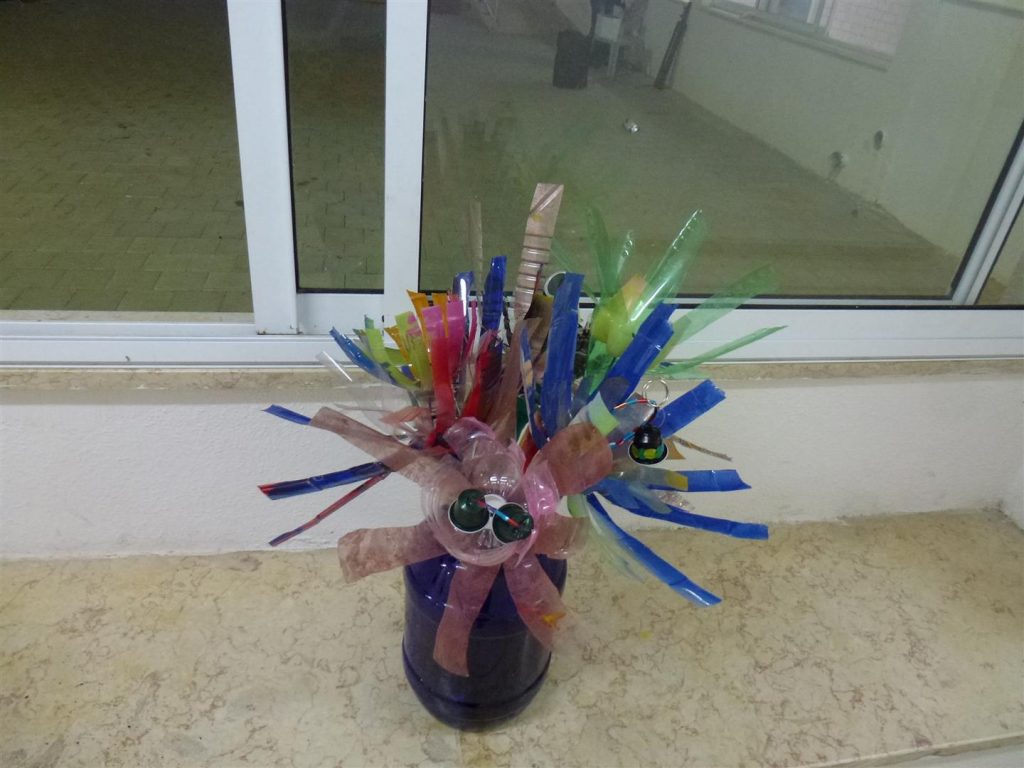 בקבוקי פלסטיק שהפכו לאגרטלים עם פרחים צבעוניים