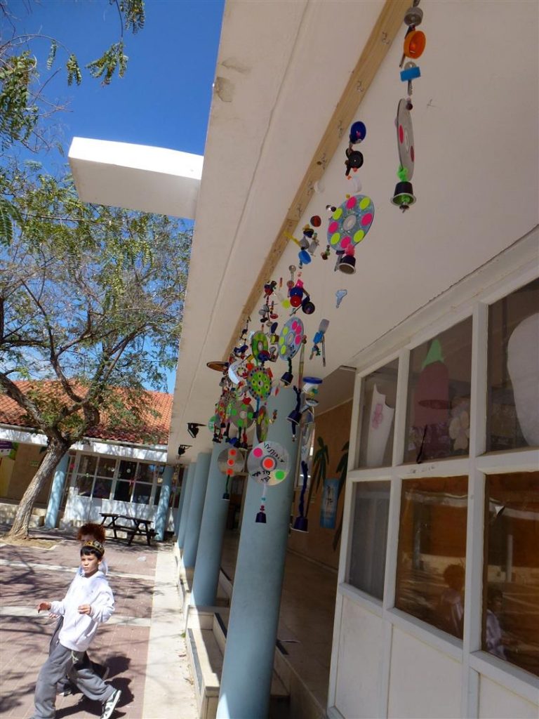 עיצוב סביבתי בחצר בית ספר דקל מחומרים ממוחזרים