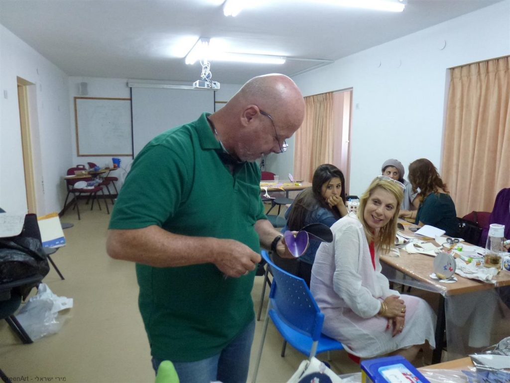 המורה עמוס עם יצירות שיצר בסדנת היצירה למורים בבית הספר העמק בעפולה