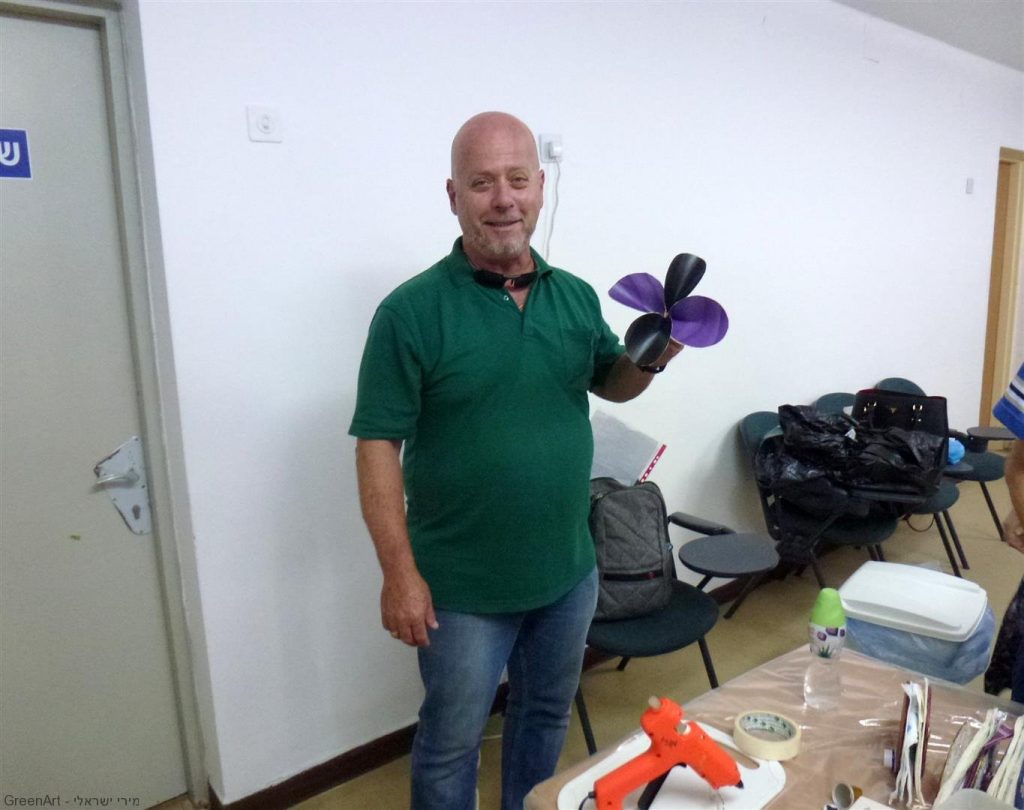 המורה עמוס עם יצירות שיצר בסדנת היצירה למורים בבית הספר העמק בעפולה