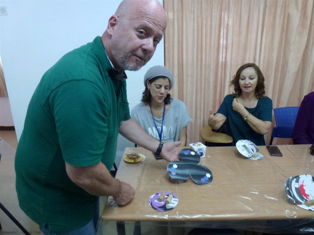 מורי בית הספר העמק בעפולה עם יצירות שיצרו מחומרים בשימוש חוזר