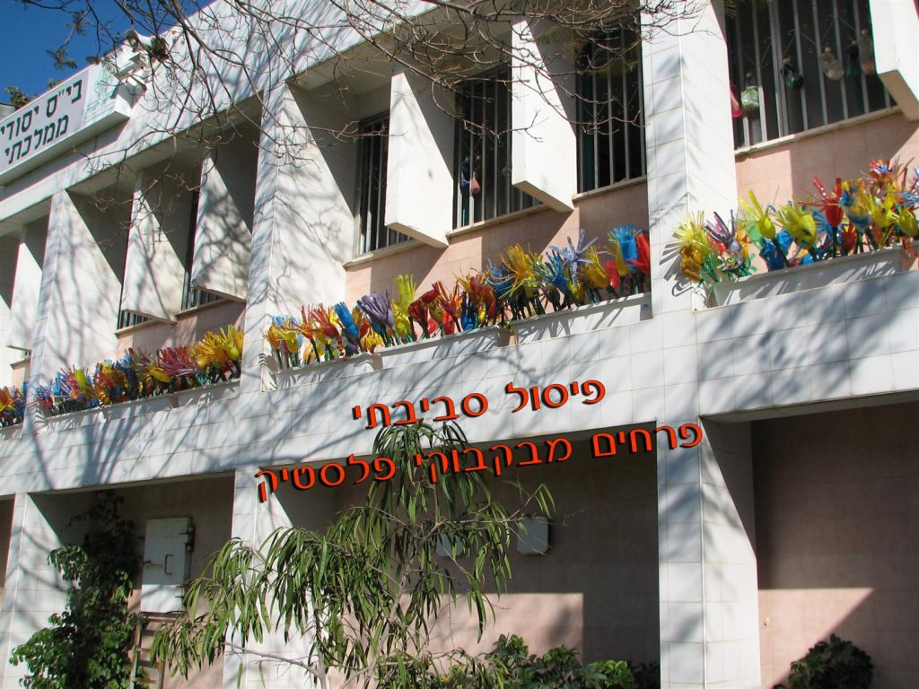 פיסול סביבתי בקבוקים שהפכו לפרחים צבעוניים בחצר בית הספ פיסול סביבתי בקבוקים שהפכו לפרחים צבעוניים בחצר בית הספ