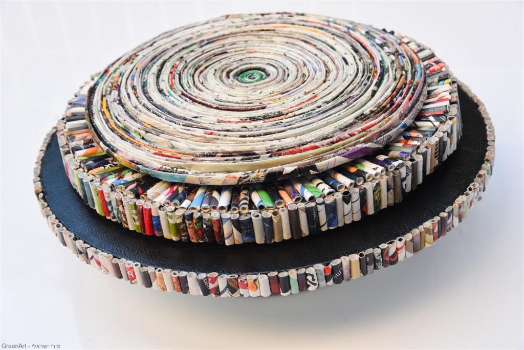 גלילי נייר צבעוניים שפוסלו לספרילה מעגלית המסתובבת על צירה. eco art.
