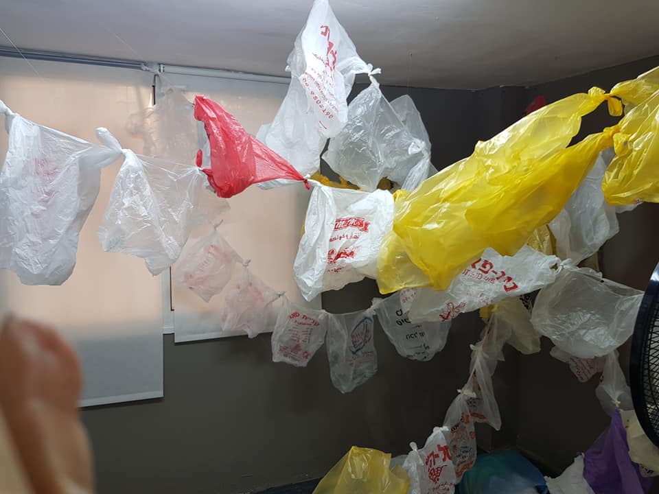 מיצב סביבתי משקיות ניילון הפסולת המצטברת כתוצאה מחומרי אריזה של מזוננו.