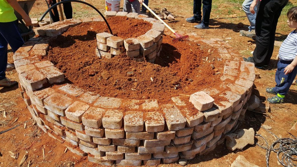 הילדים בונים את ערוגת הספירלה כהכנה לשתילת תבלינים- שנת 2016