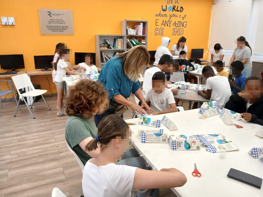תלמידי שכבת כיתות ו' לומדים בסדנת היצירה לעצב שרפרפים מקרטוני חלב לפינת ישיבה ידידותית לסביבה